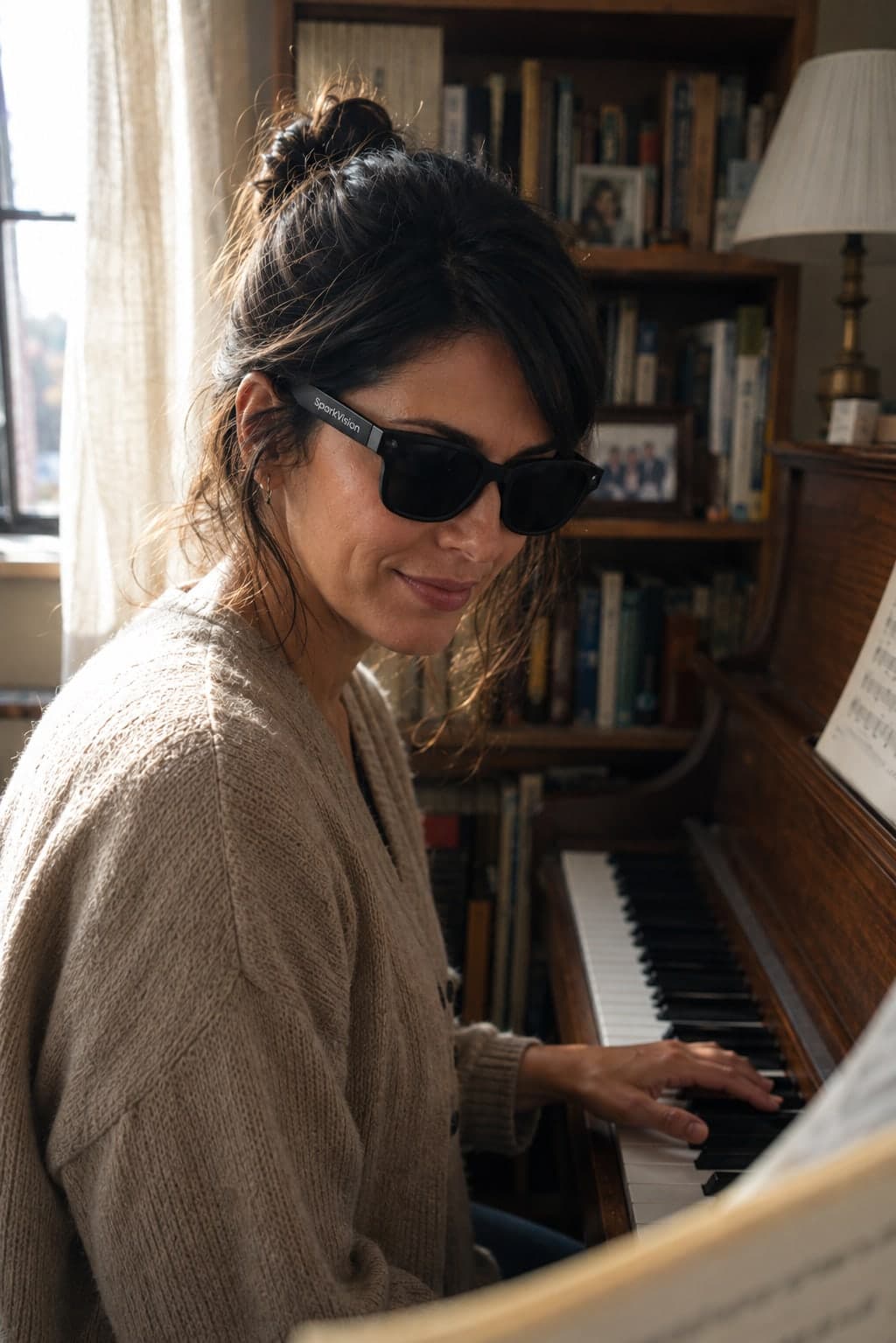 A woman wearing SparkVision Glasses 2 Ultra plays an upright piano with sheet music on the stand.